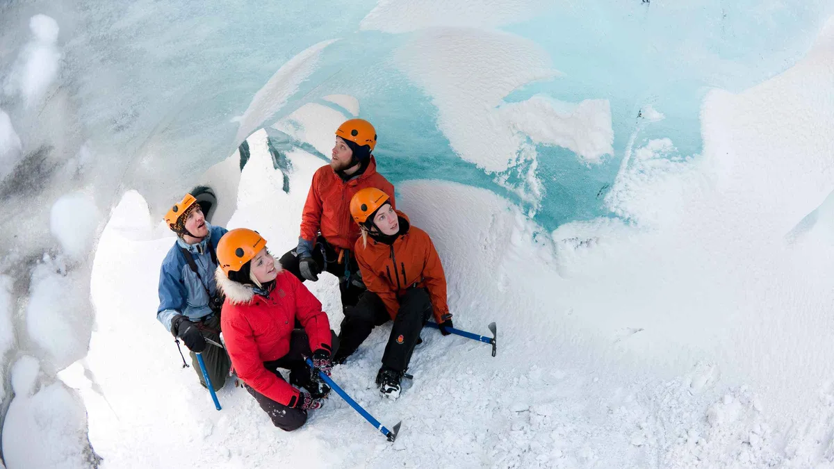 Guide briefing a group at the foot of the ice before a Sólheimajökull glacier hike near Vík, South Iceland